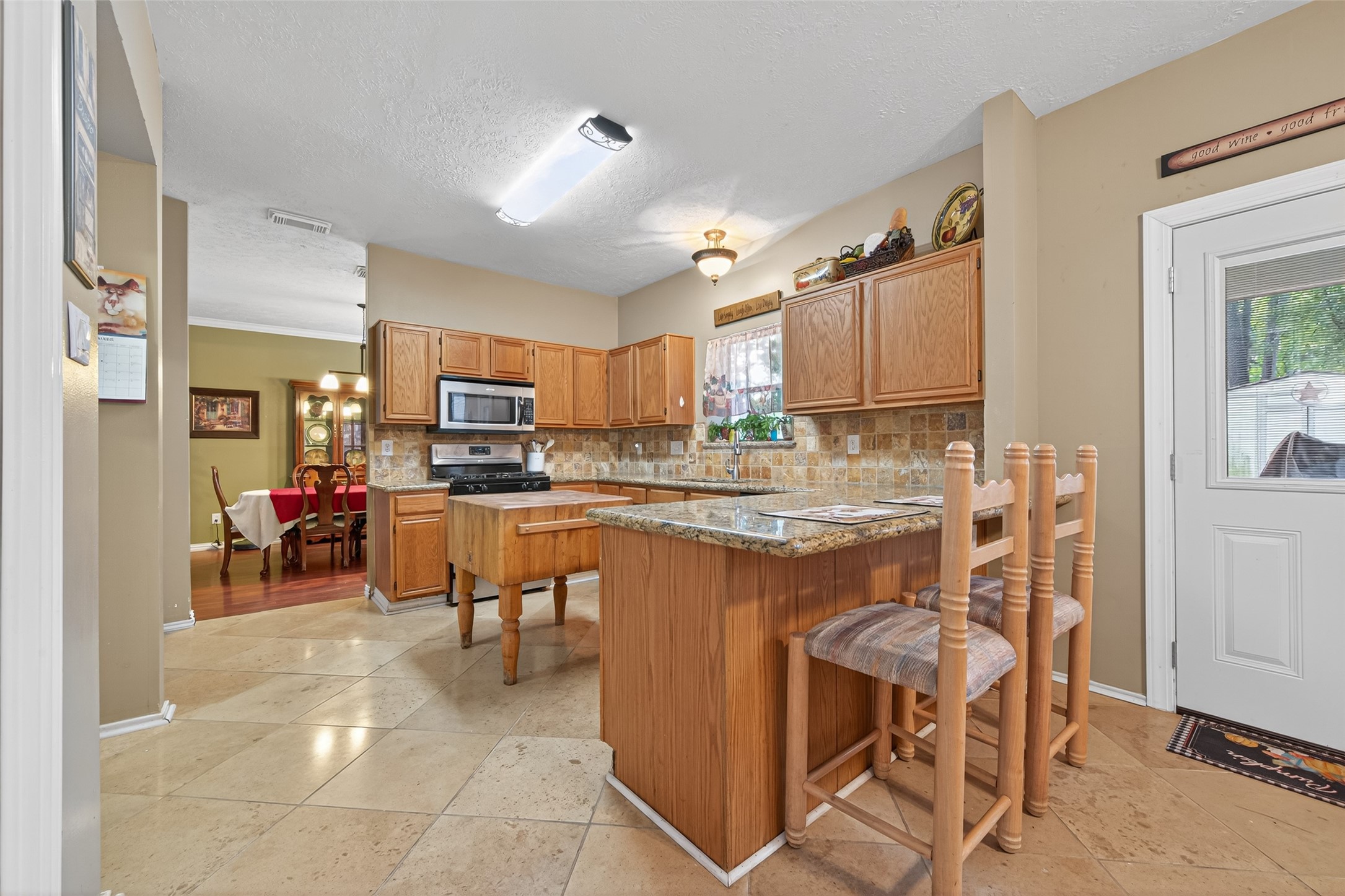17215 Chaseloch Street Spring, TX 77379 - Photo 16 of 32 a kitchen with kitchen island granite countertop wooden cabinets and counter space