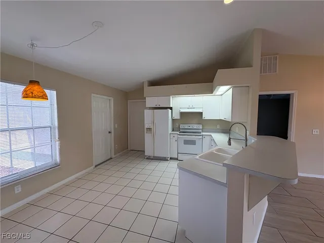 a kitchen with granite countertop a sink cabinets and appliances