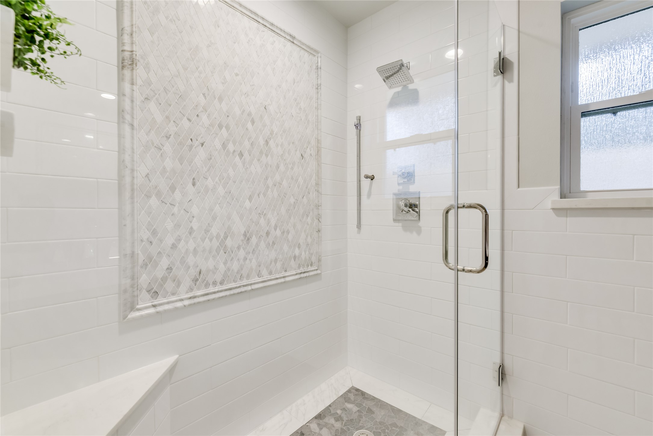 1010 Thornton Road Houston, TX 77018 - Photo 22 of 27 Modern shower with glass doors, white subway tiles, and a decorative tile accent.