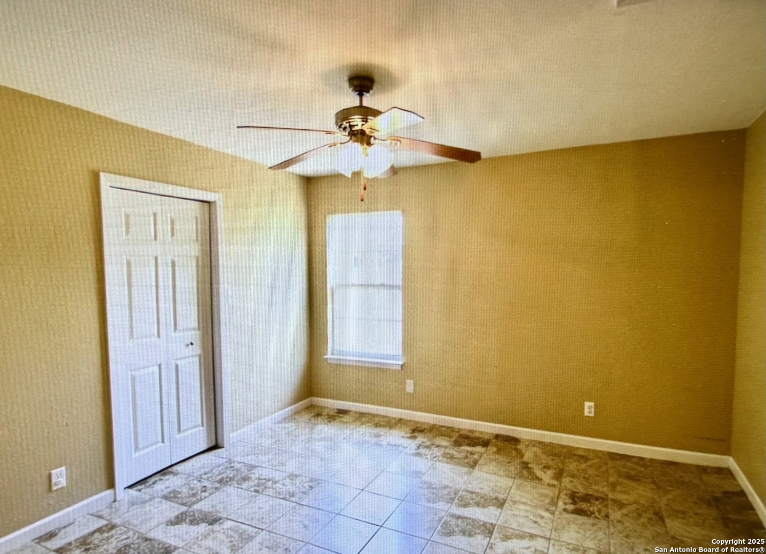 315 Mockingbird Lane Devine, TX 78016 - Photo 11 of 13 a view of an empty room with window and chandelier fan