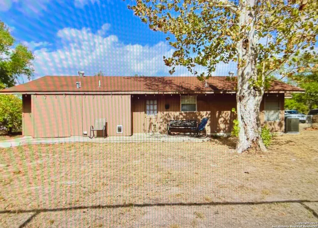a front view of a house with a tree