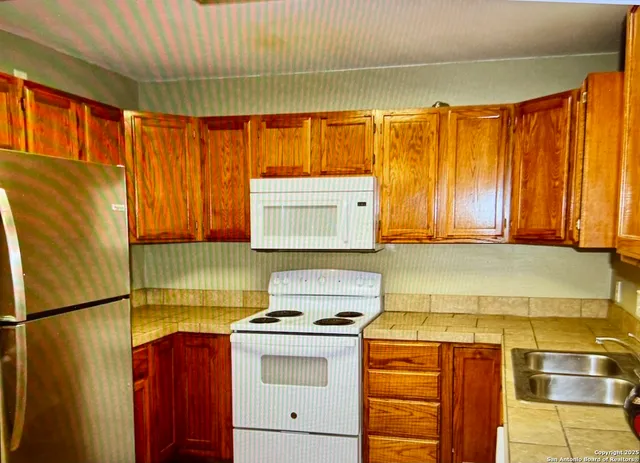 a kitchen with wooden cabinets and a stove top oven