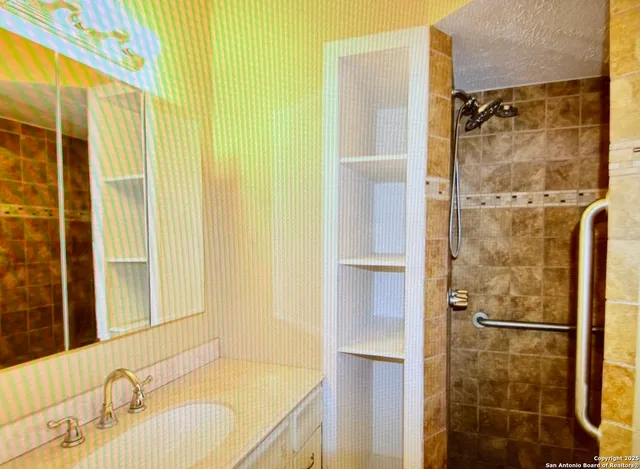 a bathroom with a granite countertop shower and a sink