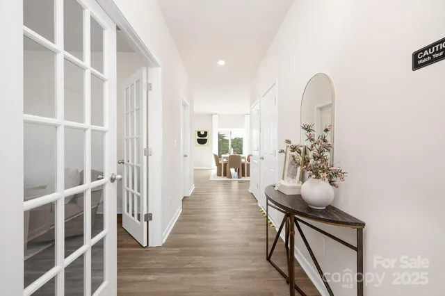 a view of a hallway with wooden floor and furniture