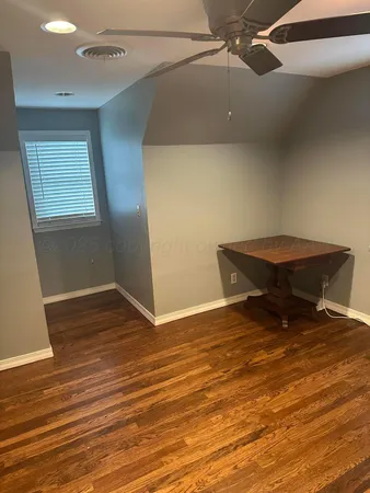 a view of room with wooden floor and fan