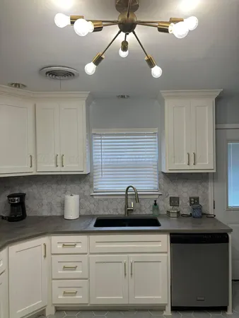 a kitchen with stainless steel appliances granite countertop a sink a stove and cabinets