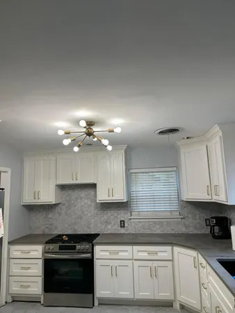 a kitchen with kitchen island granite countertop a sink stainless steel appliances and cabinets