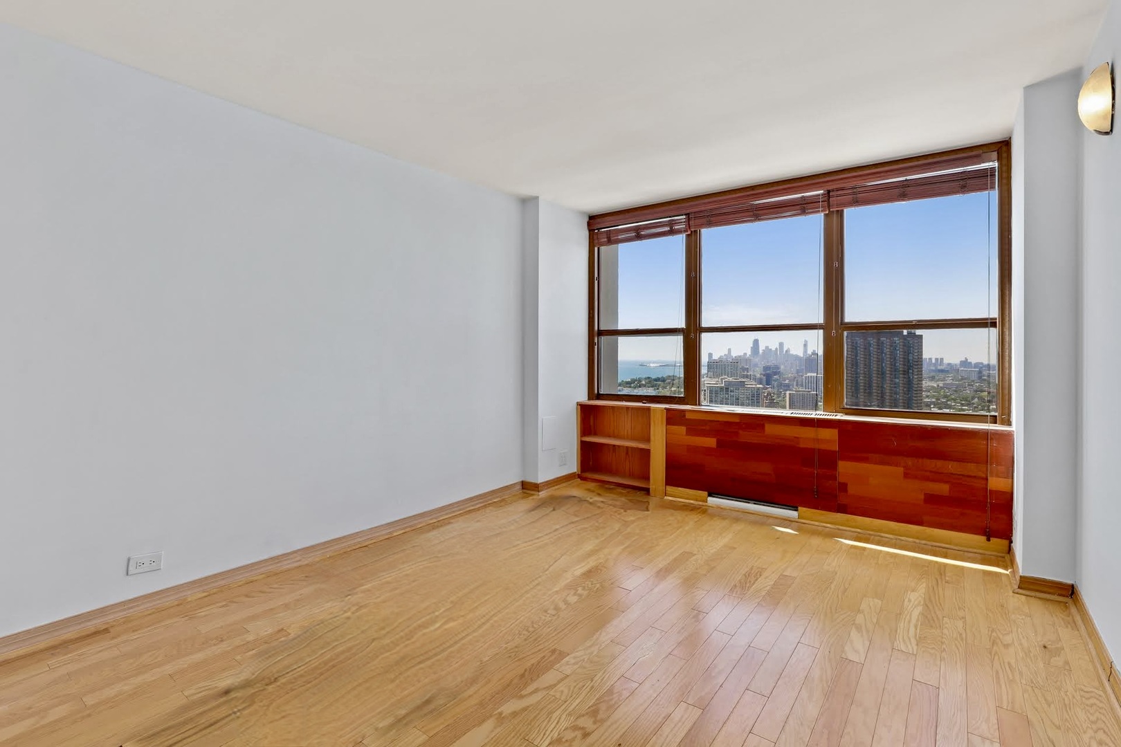 655 West Irving Park Road, Unit 4101 Chicago, IL 60613 - Photo 12 of 13 a view of an empty room with wooden floor and a window
