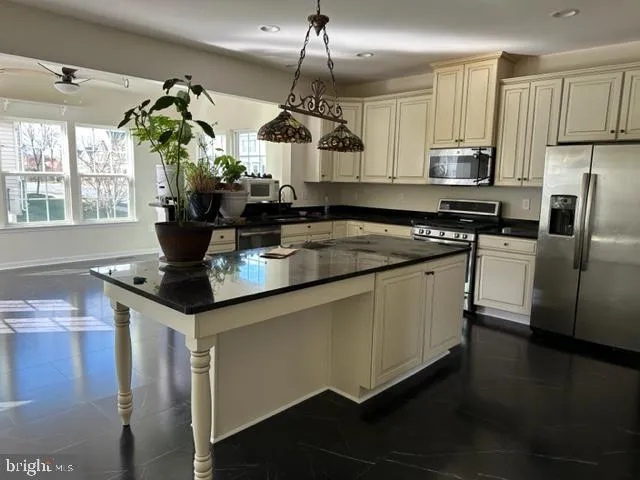 a kitchen with stainless steel appliances granite countertop a sink a stove and a refrigerator