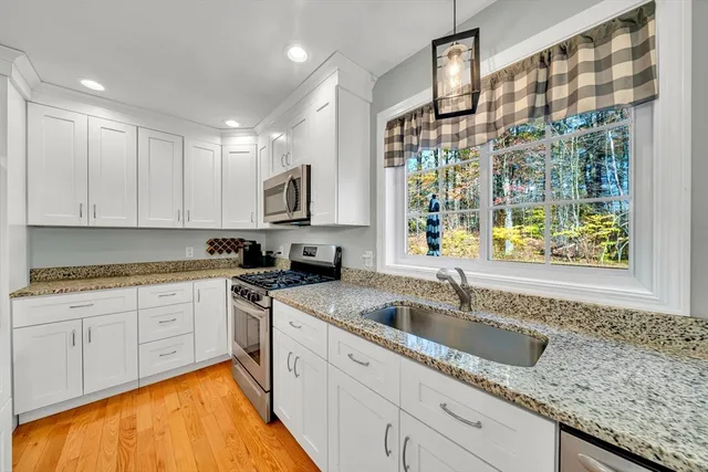 a kitchen with stainless steel appliances granite countertop a sink stove and cabinets
