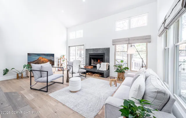 a living room with furniture fireplace and a large window