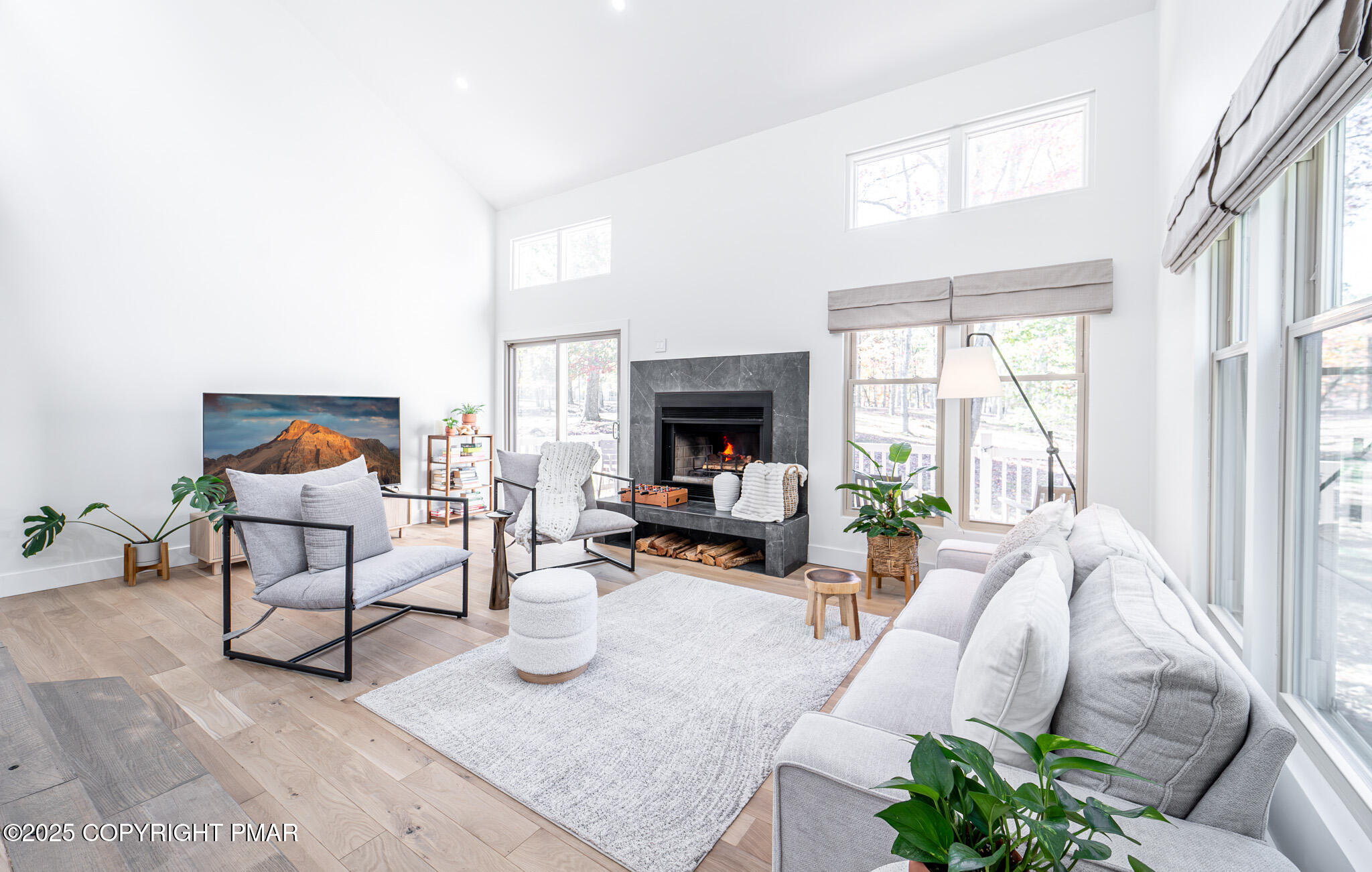 a living room with furniture fireplace and a large window