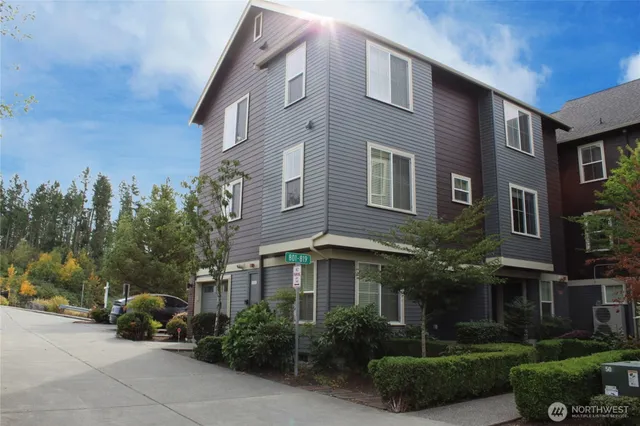 a front view of a building with garden and plants