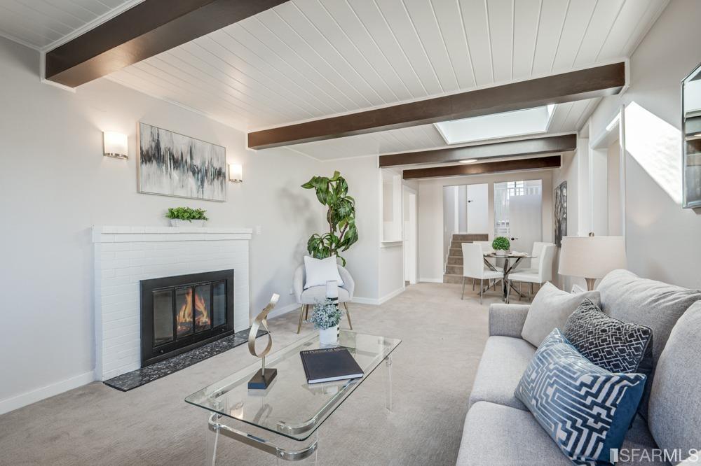 a living room with furniture a fireplace and a potted plant