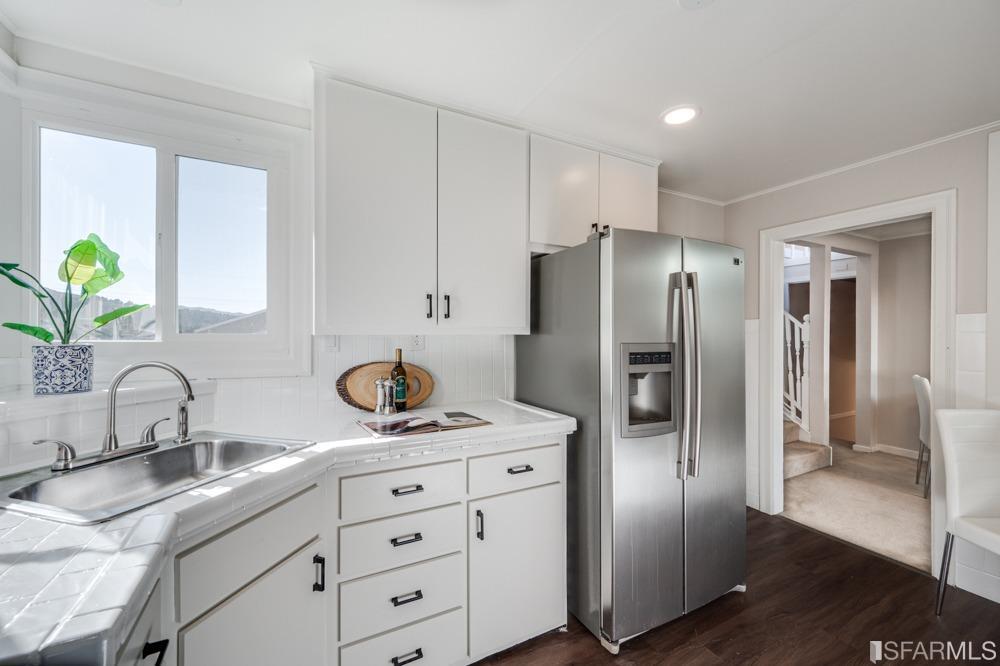 290 Clifton Road Pacifica, CA 94044 - Photo 6 of 60 a kitchen with refrigerator a sink and cabinets