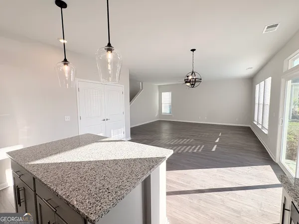 a hallway with a granite countertop stove a sink and a kitchen island