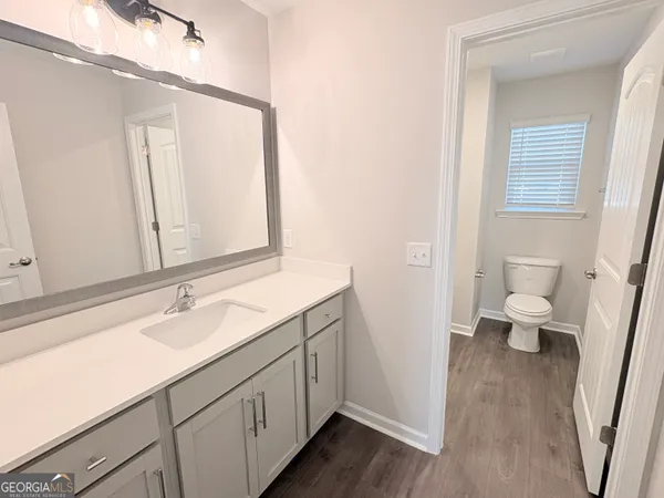 a bathroom with a sink a toilet and a mirror
