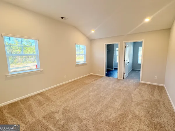 an empty room with windows and closet