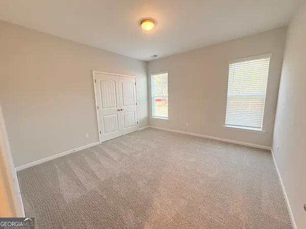 an empty room with windows and closet