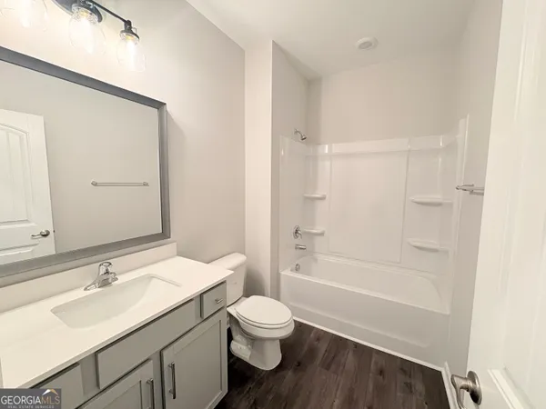 a bathroom with a granite countertop sink toilet a large mirror and shower