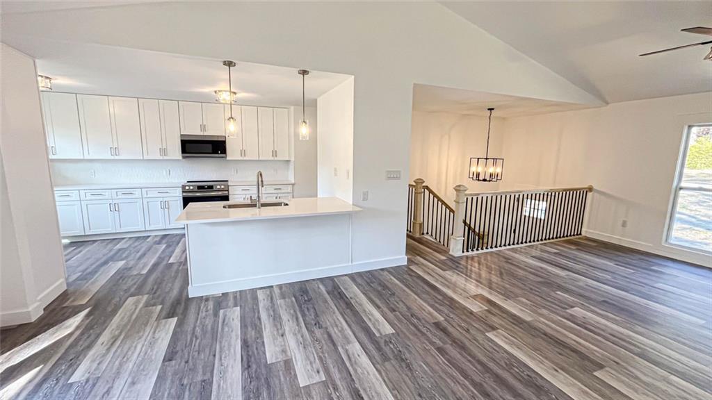 4094 Dollar Circle Suwanee, GA 30024 - Photo 23 of 56 a kitchen with stainless steel appliances a stove top oven a sink white cabinets and wooden floor