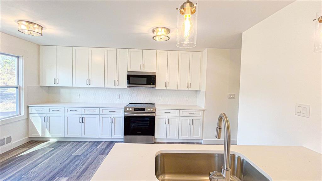 4094 Dollar Circle Suwanee, GA 30024 - Photo 26 of 56 a kitchen with stainless steel appliances granite countertop a stove a sink and a microwave