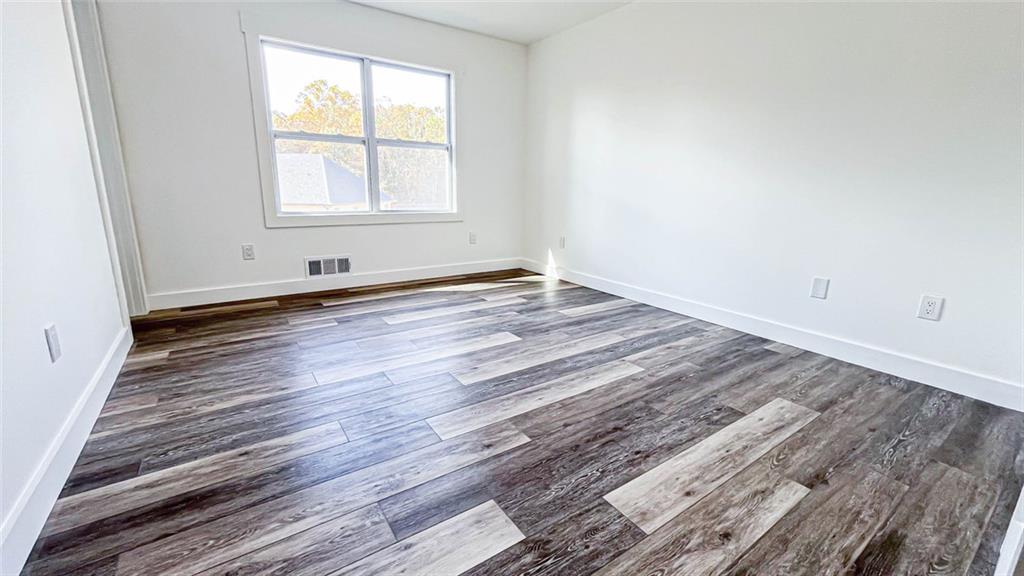 4094 Dollar Circle Suwanee, GA 30024 - Photo 32 of 56 an empty room with wooden floor and windows