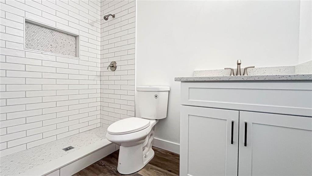 4094 Dollar Circle Suwanee, GA 30024 - Photo 39 of 56 a bathroom with a granite countertop toilet a sink and shower