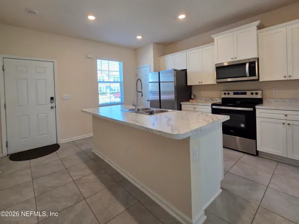 a kitchen with stainless steel appliances a sink a stove a microwave a counter top space and cabinets