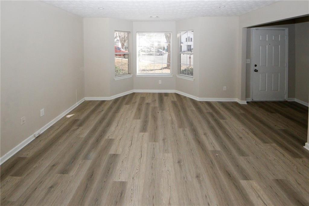 4493 Bridle Ridge Way Lithonia, GA 30038 - Photo 18 of 35 an empty room with wooden floor and windows