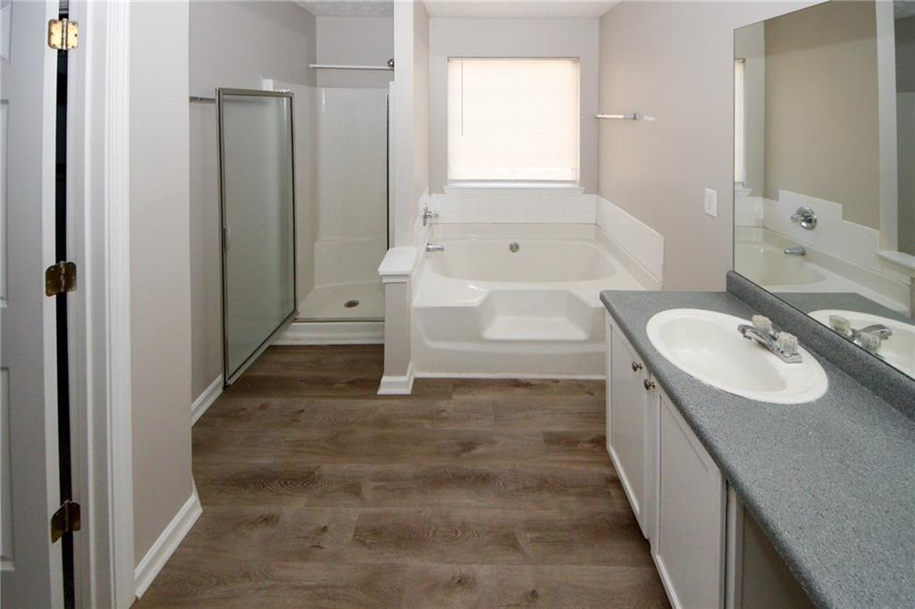 4493 Bridle Ridge Way Lithonia, GA 30038 - Photo 23 of 35 a bathroom with a tub sink and mirror