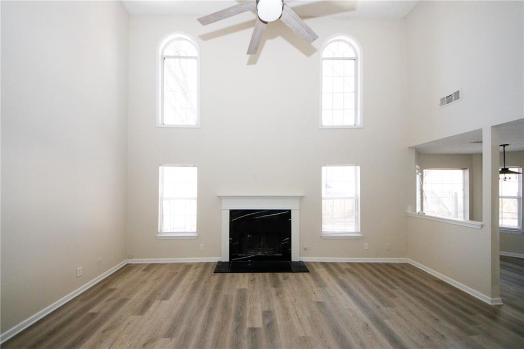 4493 Bridle Ridge Way Lithonia, GA 30038 - Photo 3 of 35 an empty room with wooden floor windows and fireplace
