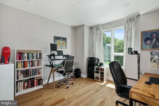 a view of a workspace with furniture and a bookshelf