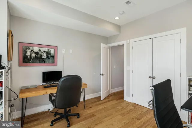 a view of a workspace with furniture and a window