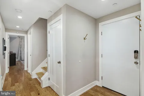 a view of a hallway with wooden floor and entryway