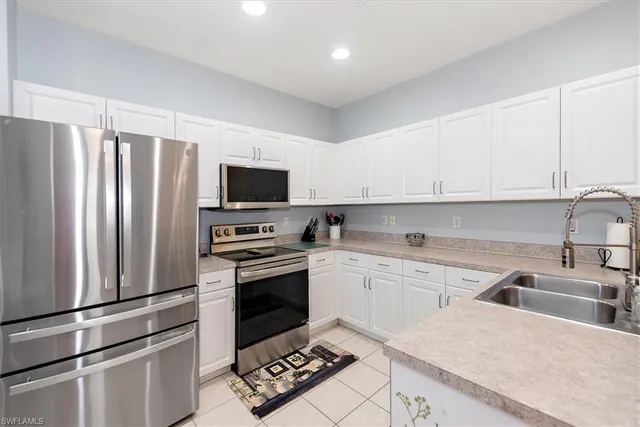 a view of a kitchen with granite countertop a sink and a stove top oven