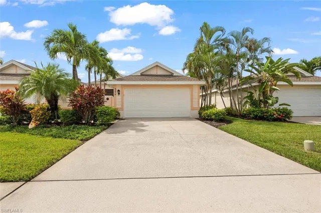 a living room with furniture a flat screen tv and kitchen view