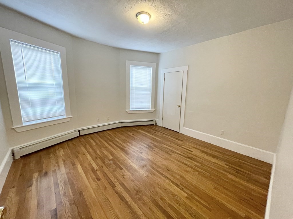 11 Elder Street, Unit 3 Boston, MA 02125 - Photo 15 of 26 an empty room with wooden floor and windows