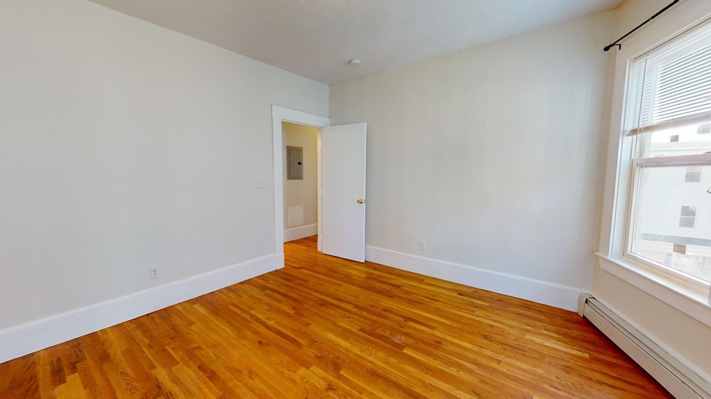 11 Elder Street, Unit 3 Boston, MA 02125 - Photo 19 of 26 a view of empty room with wooden floor and fan