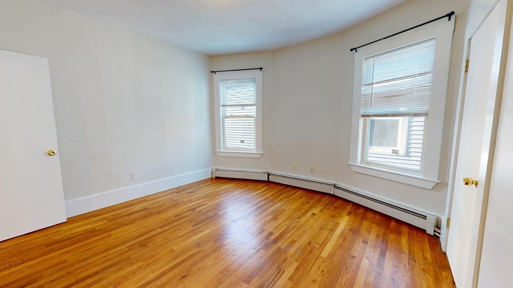 11 Elder Street, Unit 3 Boston, MA 02125 - Photo 22 of 26 a view of an empty room with wooden floor and a window