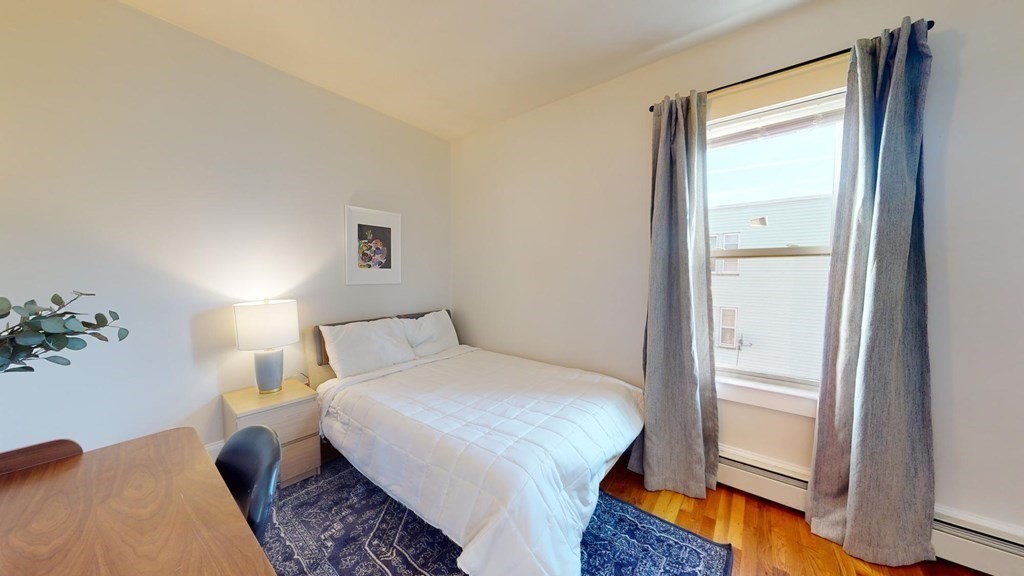 11 Elder Street, Unit 3 Boston, MA 02125 - Photo 6 of 26 a bedroom with a bed and a large mirror