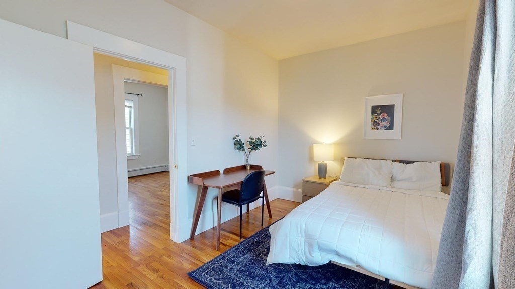11 Elder Street, Unit 3 Boston, MA 02125 - Photo 7 of 26 a bedroom with a bed and wooden floor