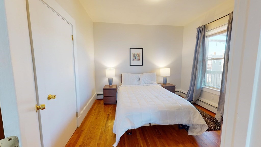 11 Elder Street, Unit 3 Boston, MA 02125 - Photo 9 of 26 a bedroom with a bed and wooden floor