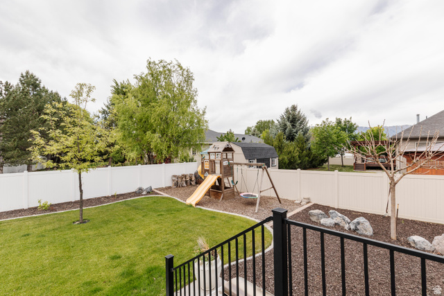 972 West 2840th Street South Logan, UT 84321 - Photo 33 of 46 Expansive backyard featuring a lush lawn, white privacy fencing, and mature trees