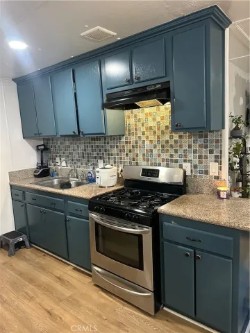 a kitchen with granite countertop a stove sink and cabinets