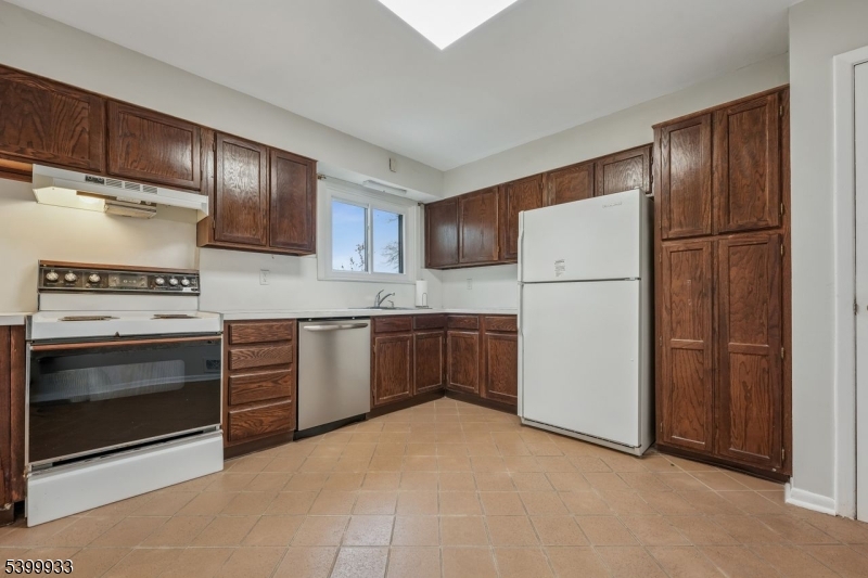 35 South Derby Road Springfield, NJ 07081 - Photo 15 of 30 a kitchen with a refrigerator sink stove and cabinets