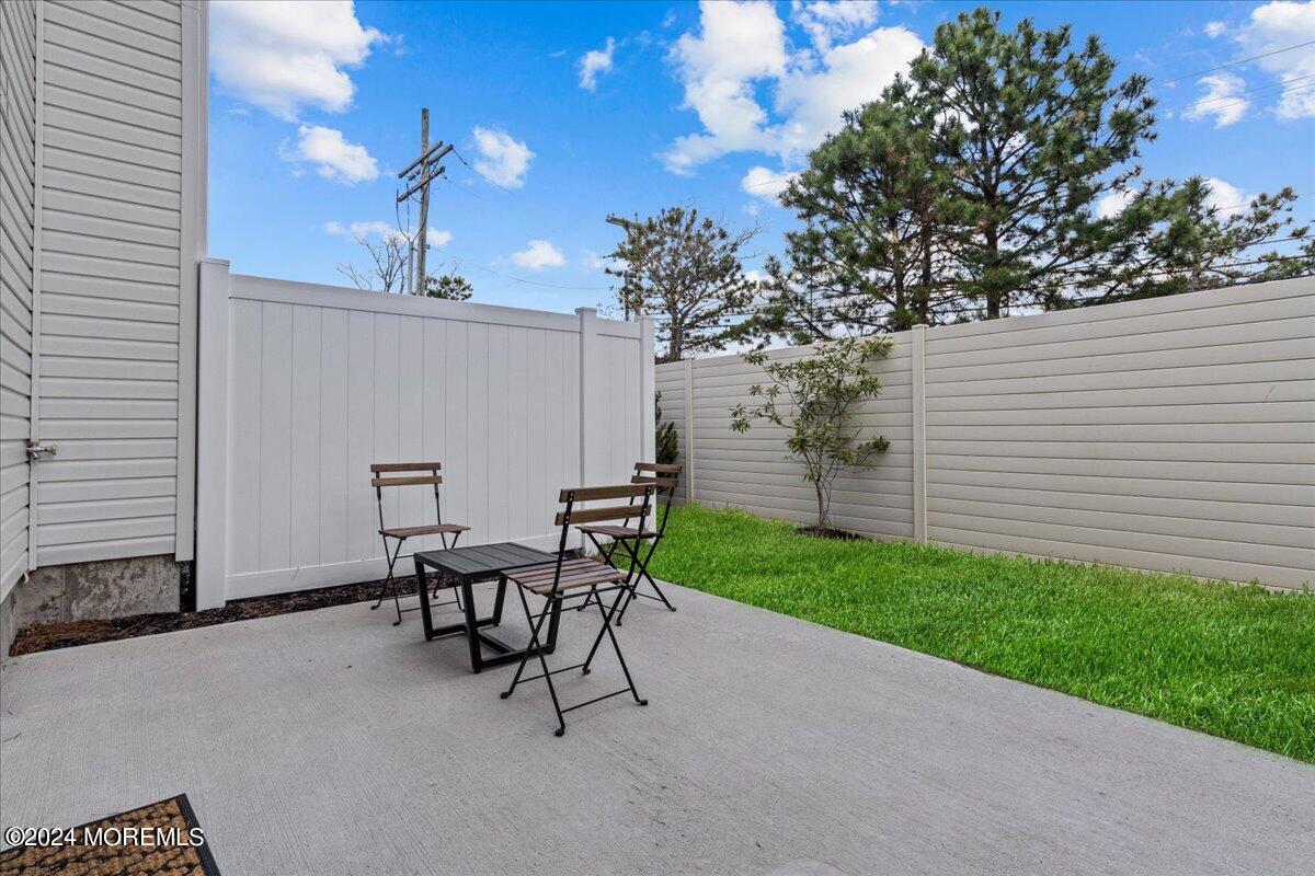 104 Prestige Road Brick, NJ 08723 - Photo 38 of 43 a view of a patio with table and chairs and potted plants with wooden fence