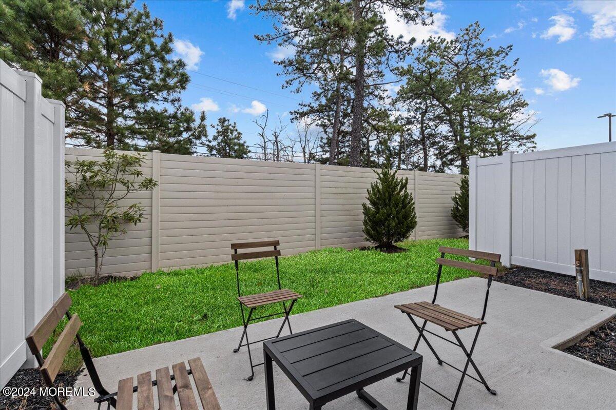 104 Prestige Road Brick, NJ 08723 - Photo 39 of 43 a view of a backyard with table and chairs with wooden fence and plants