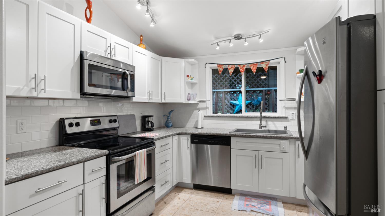 15246 Rio Nido Road Guerneville, CA 95446 - Photo 8 of 24 a kitchen with stainless steel appliances granite countertop white cabinets a sink a stove a refrigerator and a microwave