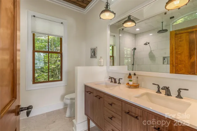 a bathroom with a granite countertop double vanity sink mirror bathtub and toilet